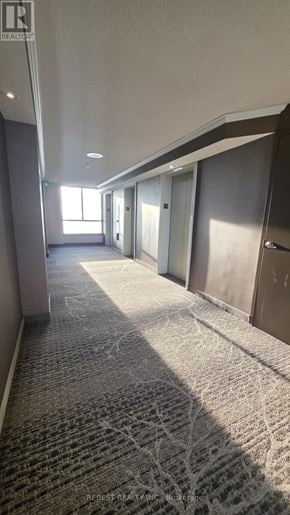 Mississauga (Hurontario) condo for rent - A long hallway with carpeted floors and doors on both sides.