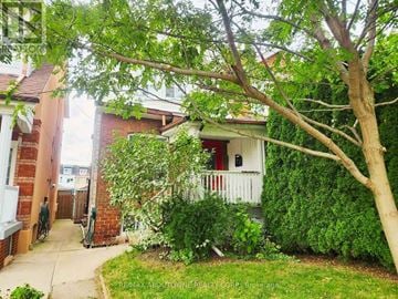 Toronto (Weston-Pellam Park) apartment for rent - A tree is in front of a house.