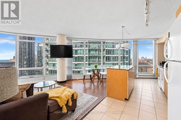 Toronto (Waterfront Communities) condo for rent - A living room with a brown couch and a yellow throw blanket.