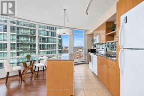 Toronto (Waterfront Communities) condo for rent - A kitchen with a table and chairs in front of a window with a view of a cityscape.