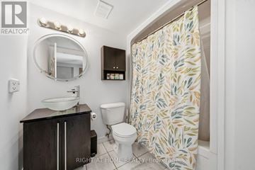 Guelph (Grange Road) condo for rent - A bathroom with a sink, toilet and shower curtain.