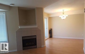 Edmonton townhouse for rent - A living room with a fireplace and a chandelier.
