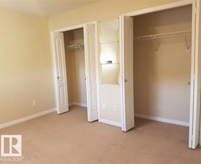 Edmonton townhouse for rent - A bedroom with a white closet and a white door.