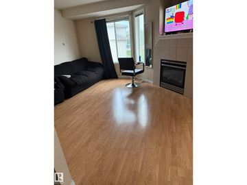 Edmonton townhouse for rent - A living room with a black couch and a television on the wall.