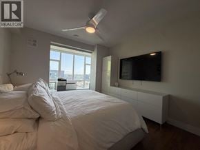 Vancouver apartment for rent - A bedroom with a large bed and a flat screen TV mounted on the wall.