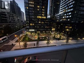 Toronto (Mount Pleasant West) condo for rent - A cityscape at night with a building that has a "REALTOR" sign on it.