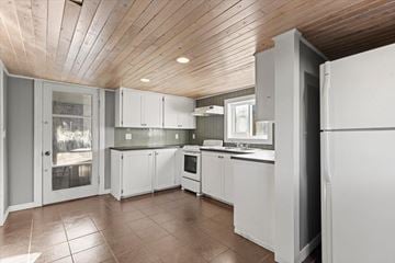Chilliwack apartment for rent - A kitchen with white cabinets and a wooden ceiling.
