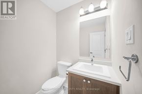 Ottawa townhouse for rent - A white toilet sits next to a sink in a bathroom.