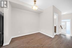 Ottawa townhouse for rent - A well-lit, empty room with wooden flooring and white walls.