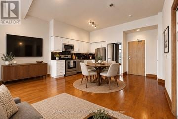 Toronto (The Beaches) condo for rent - A modern kitchen with a dining table set in the middle.