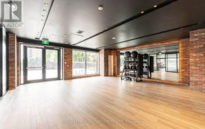 Toronto (Humber Heights) condo for rent - A spacious room with wooden floors and brick walls.