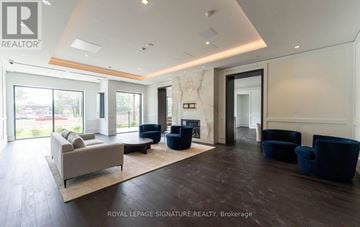 Toronto (Humber Heights) condo for rent - A spacious living room with a couch, chairs, and a fireplace.