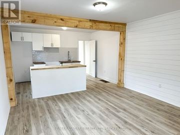St. Catharines (Western Hill) apartment for rent - A kitchen with white cabinets and a wooden beam on the wall.