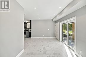 Kitchener condo for rent - A spacious room with a marble floor and a sliding glass door leading to a garden.