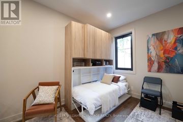 Toronto (Kensington-Chinatown) apartment for rent - A modern kitchen with wooden chairs and a refrigerator.
