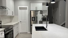 Edmonton apartment for rent - A modern kitchen with white cabinets and stainless steel appliances.