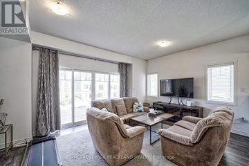 Wasaga Beach townhouse for rent - A living room with a large couch and a television.