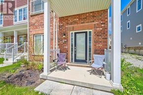 Wasaga Beach townhouse for rent - A red brick house with a porch and two chairs.