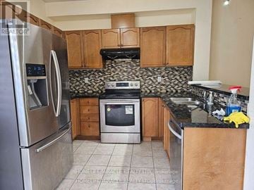 Brampton (Bram West) apartment for rent - A kitchen with a black and white tiled backsplash.