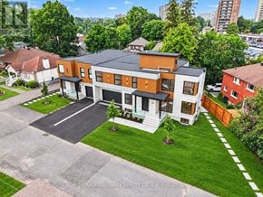 Ottawa apartment for rent - A modern two-story house with a large front yard and a driveway.