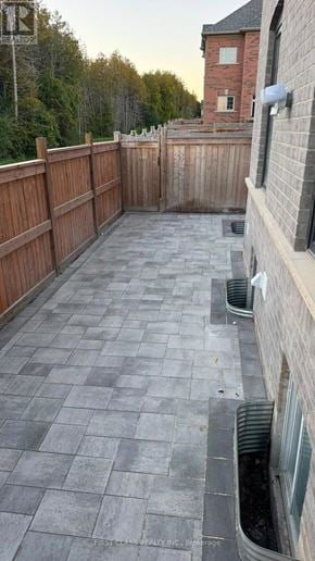 Whitby (Rolling Acres) apartment for rent - A backyard with a wooden fence and a brick building in the background.