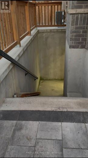Whitby (Rolling Acres) apartment for rent - A concrete stairwell with a wooden handrail and a brick wall.