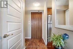 Brampton (Queen Street Corridor) condo for rent - A hallway with a wooden door and a white door on the left.