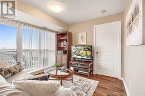 Brampton (Queen Street Corridor) condo for rent - A living room with a couch, a coffee table, a television, and a sliding glass door.