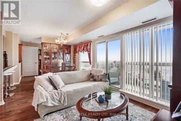 Brampton (Queen Street Corridor) condo for rent - A living room with a white couch and a chandelier.