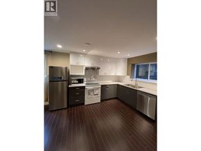 Coquitlam apartment for rent - A modern kitchen with dark wood floors and stainless steel appliances.