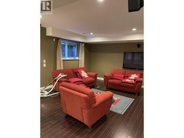 Coquitlam apartment for rent - A living room with red couches and a flat screen TV.