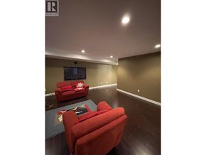 Coquitlam apartment for rent - A living room with a red couch and a television.