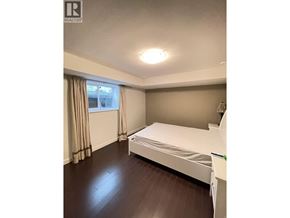 Coquitlam apartment for rent - A bedroom with a bed, window, and curtains.