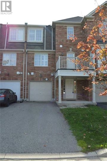 Milton (Co Coates) townhouse for rent - A house with a garage and a tree with orange leaves in front.