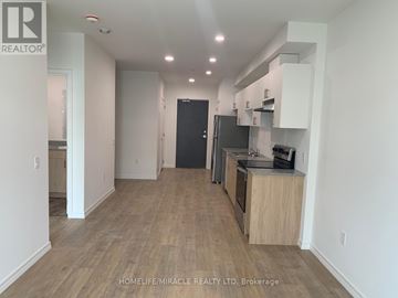 Guelph (Willow West/Sugarbush/West Acres) condo for rent - A kitchen area with a black refrigerator and wooden flooring.