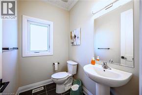 Kitchener apartment for rent - A bathroom with a toilet, sink, and mirror.