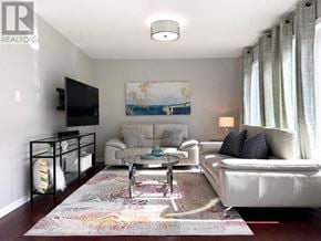 Milton (Ha Harrison) townhouse for rent - A living room with a white couch, a coffee table, and a painting on the wall.