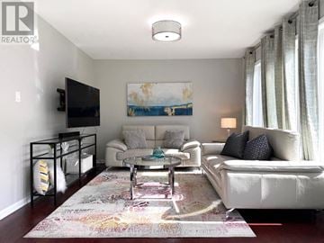 Milton (Ha Harrison) townhouse for rent - A living room with a white couch, a coffee table, and a painting on the wall.