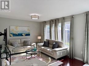 Milton (Ha Harrison) townhouse for rent - A living room with a white couch, a glass coffee table, and a painting on the wall.