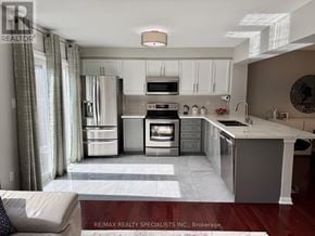 Milton (Ha Harrison) townhouse for rent - A modern kitchen with white appliances and a marble countertop.