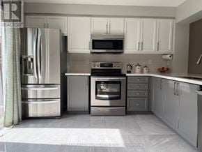 Milton (Ha Harrison) townhouse for rent - A modern kitchen with stainless steel appliances and white cabinets.