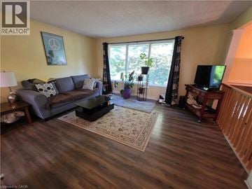 Waterloo apartment for rent - A living room with a grey couch and a wooden floor.