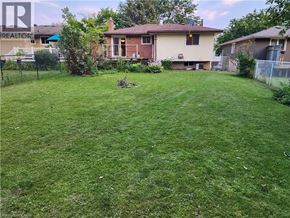 Waterloo apartment for rent - A backyard with a lawn and a house in the background.
