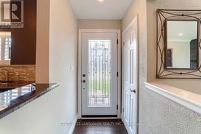 Oshawa (Mclaughlin) apartment for rent - A hallway with a mirror on the wall and a door with a window.