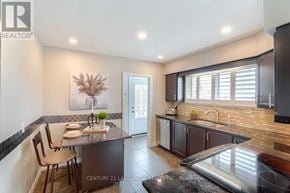 Oshawa (Mclaughlin) apartment for rent - A kitchen with a table set for two and a plant on the counter.