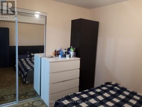 Vaughan (Patterson) apartment for rent - A bedroom with a bed, a dresser, and a wardrobe.