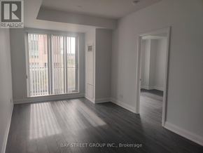 Markham (Unionville) condo for rent - A spacious room with wooden flooring and a large window with blinds.