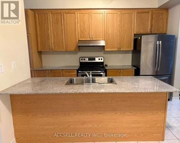 Markham (Village Green-South Unionville) townhouse for rent - A kitchen with wooden cabinets and a granite countertop.