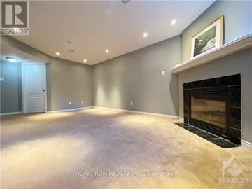 Ottawa townhouse for rent - A spacious living room with a fireplace and a painting on the wall.