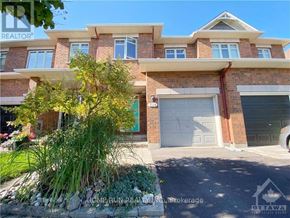 Ottawa townhouse for rent - A two-story brick house with a garage door and a driveway.